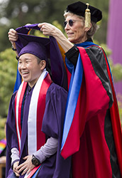 A photo of a student receiving a graduate hood.